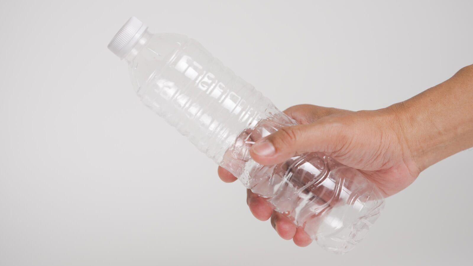 Person holding plastic bottle
