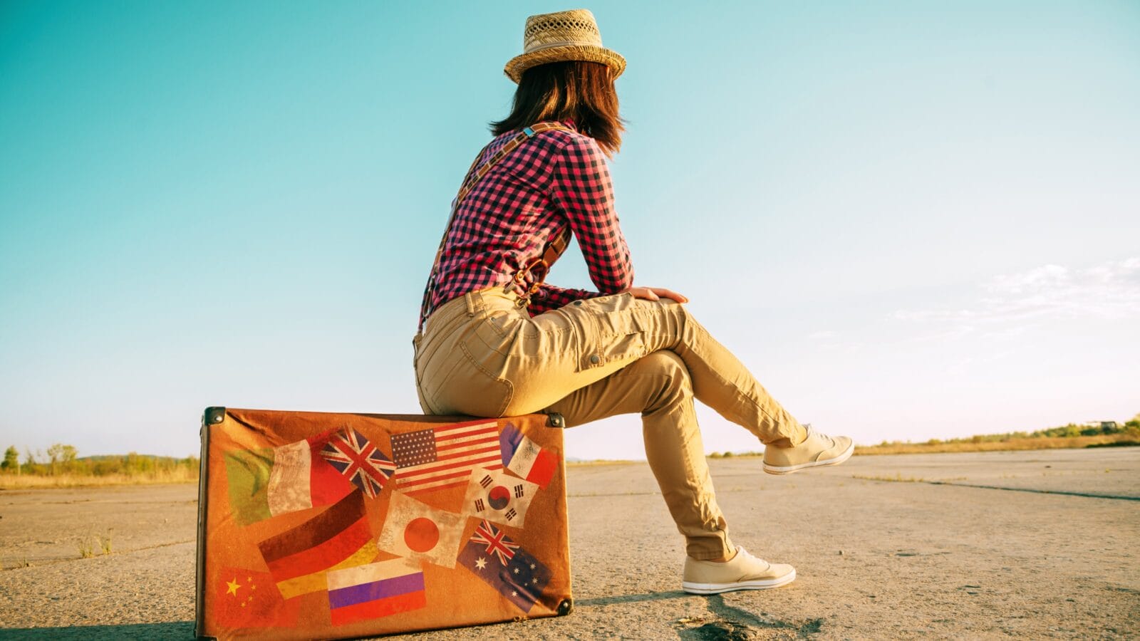 Woman sitting on luggage.