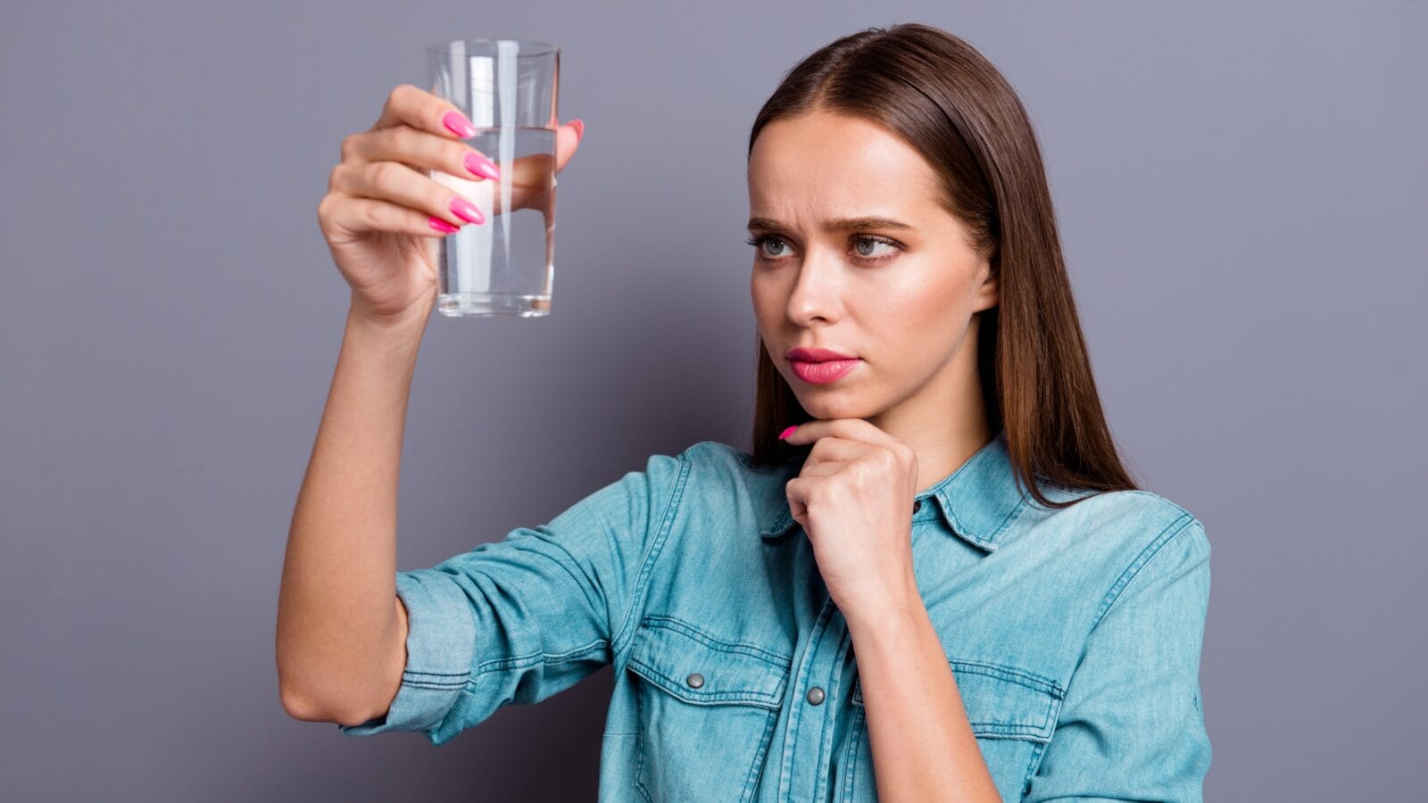 Close up portrait of a woman holding a glass of water.