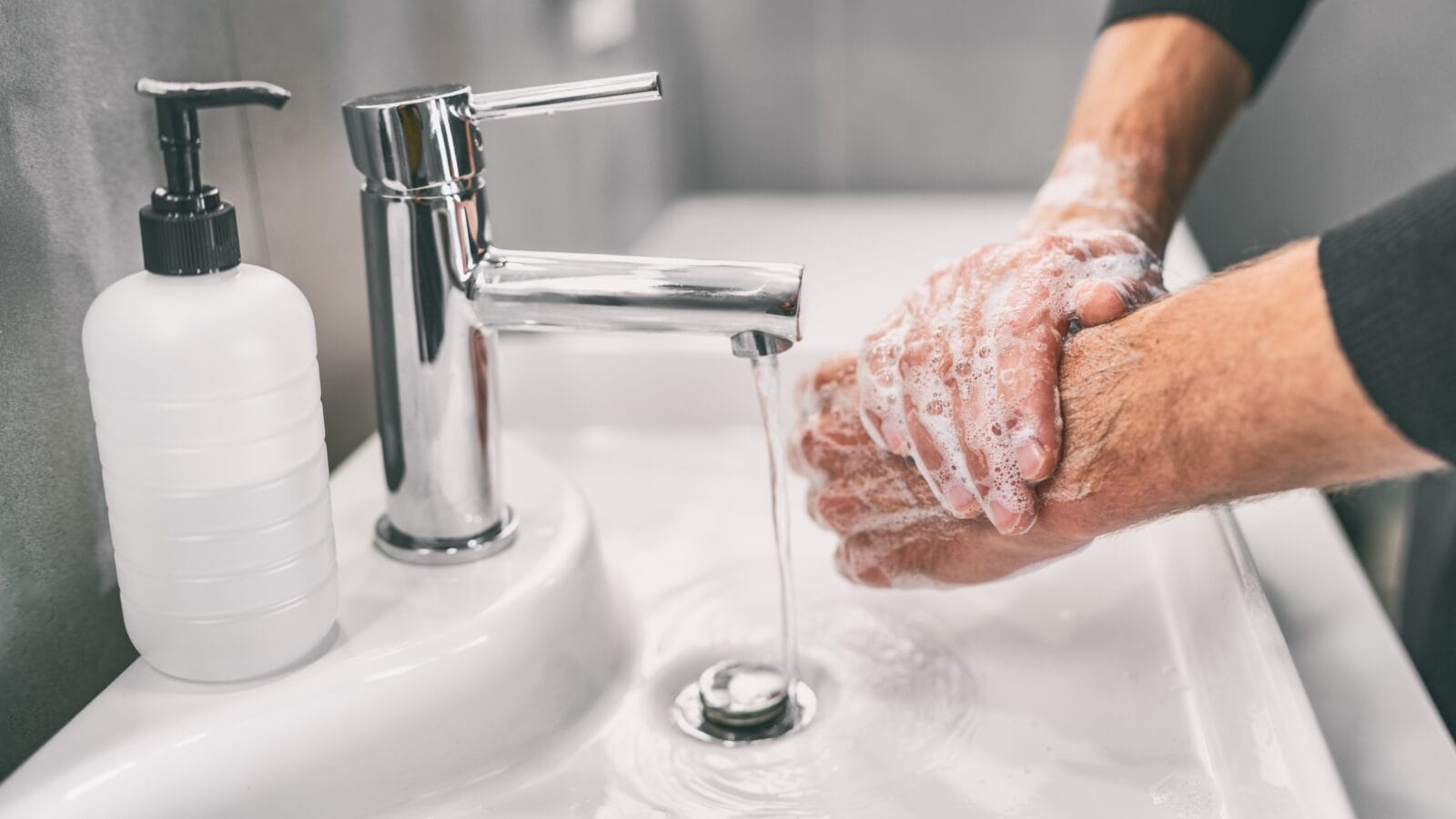 A man washing hands rubbing with soap