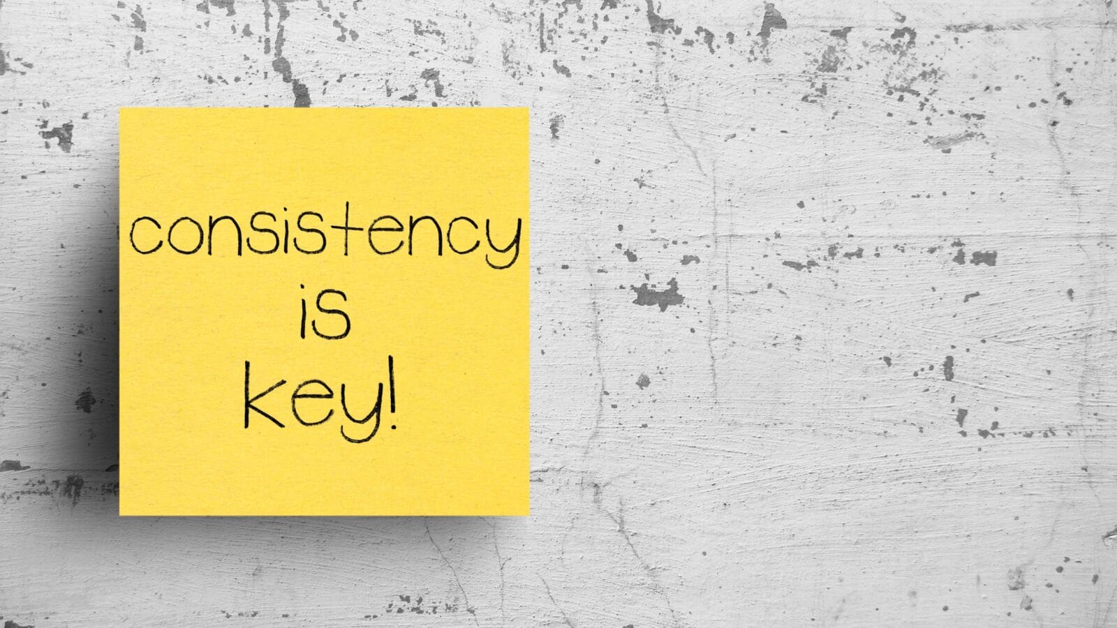Sticky note on concrete wall, Consistency is key