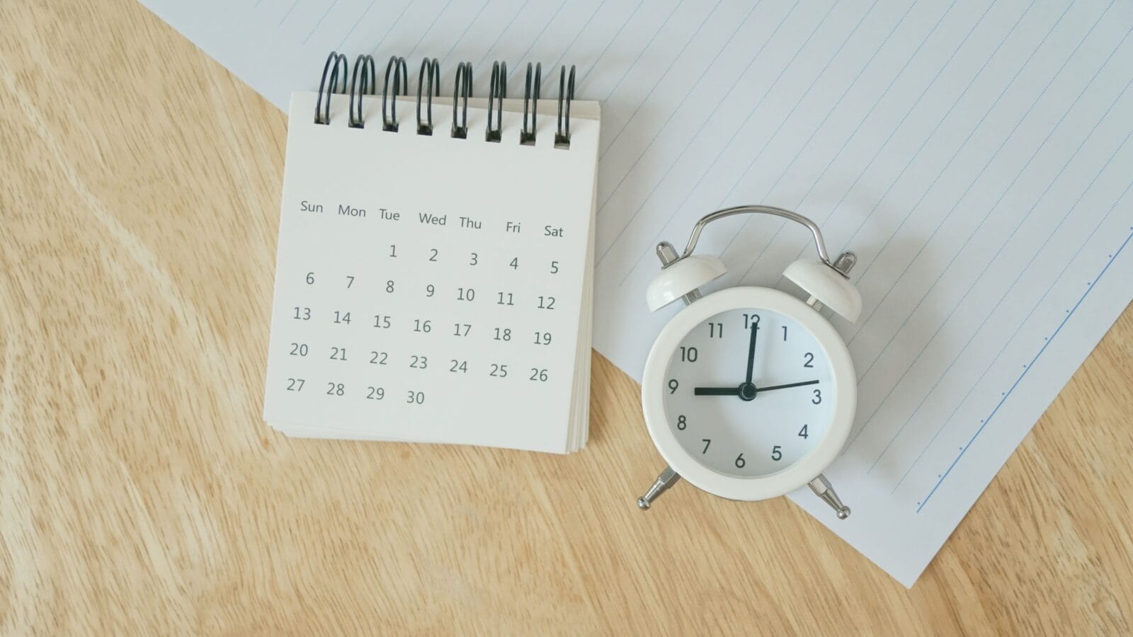 White calendar and analog alarm clock