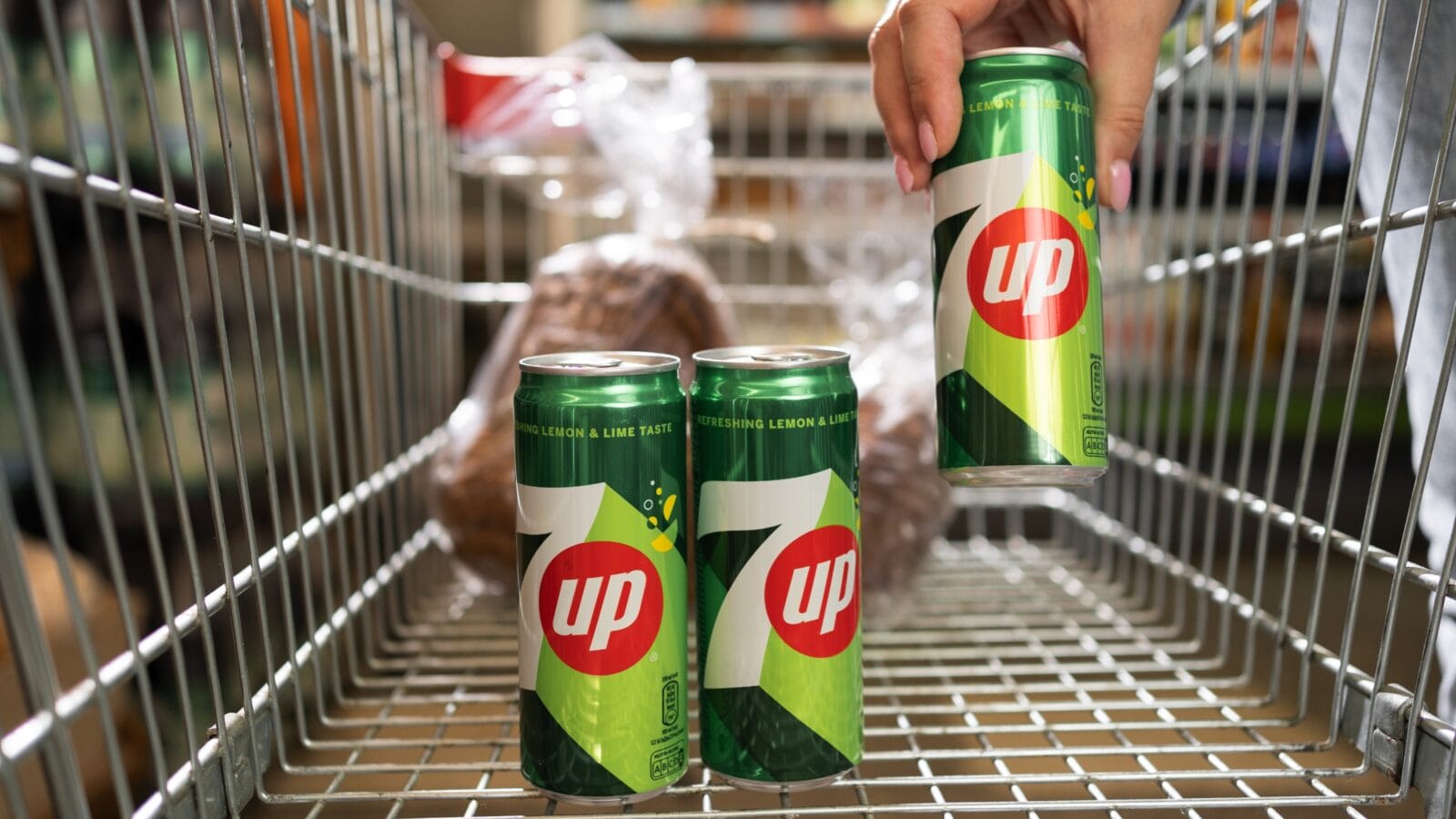 Shopper hand holding a can with 7up.
