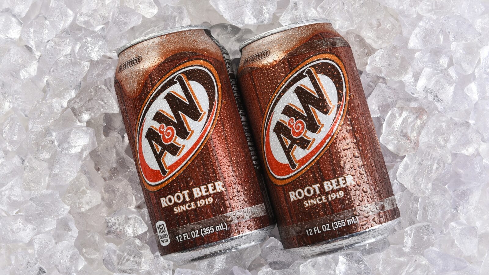 Two cans of A and W Root Beer on a bed of ice.