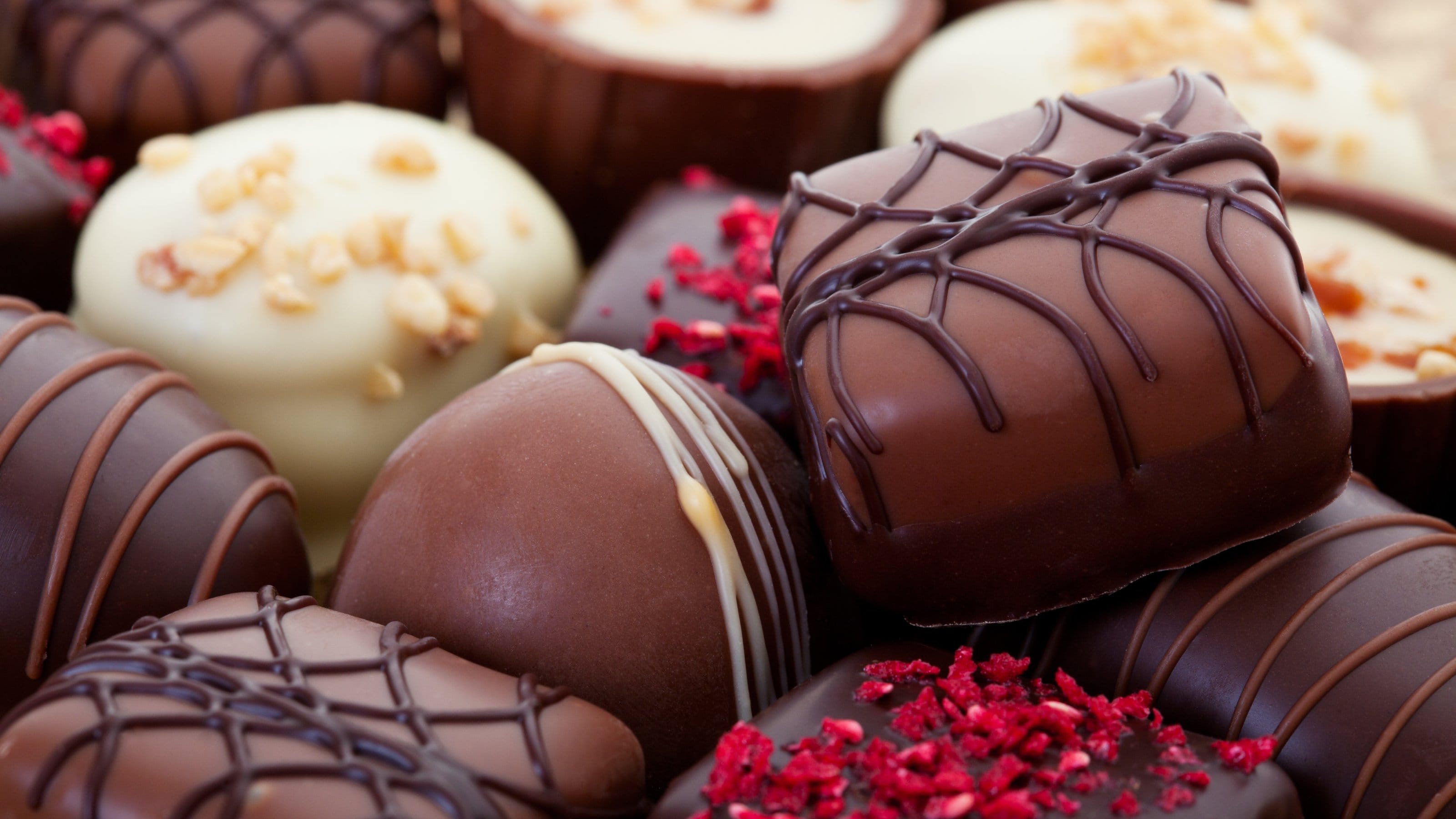 An assortment of fine chocolates in white, dark, and milk chocolate.