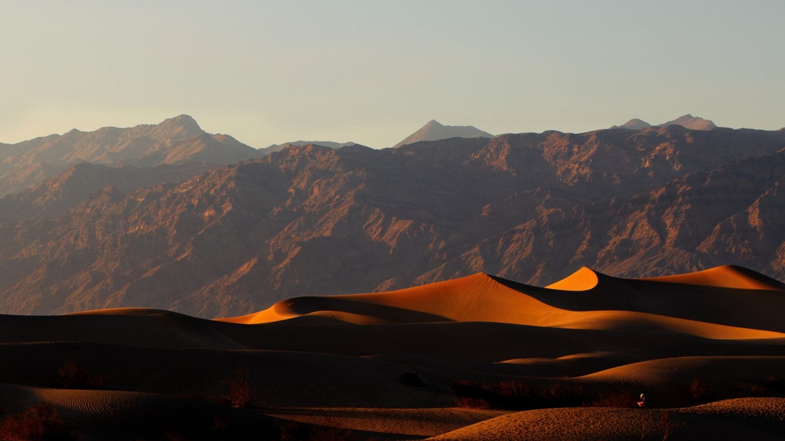 Golden sunlight casting shadows on the rippled desert landscape at Death Valley National Park, California.