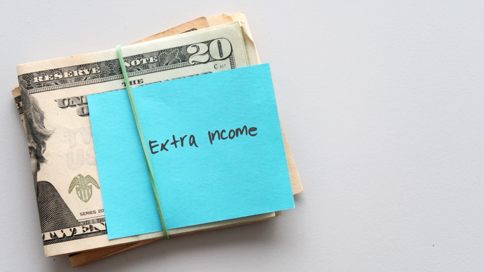 Dollars cash money and paper note with text written Extra income.