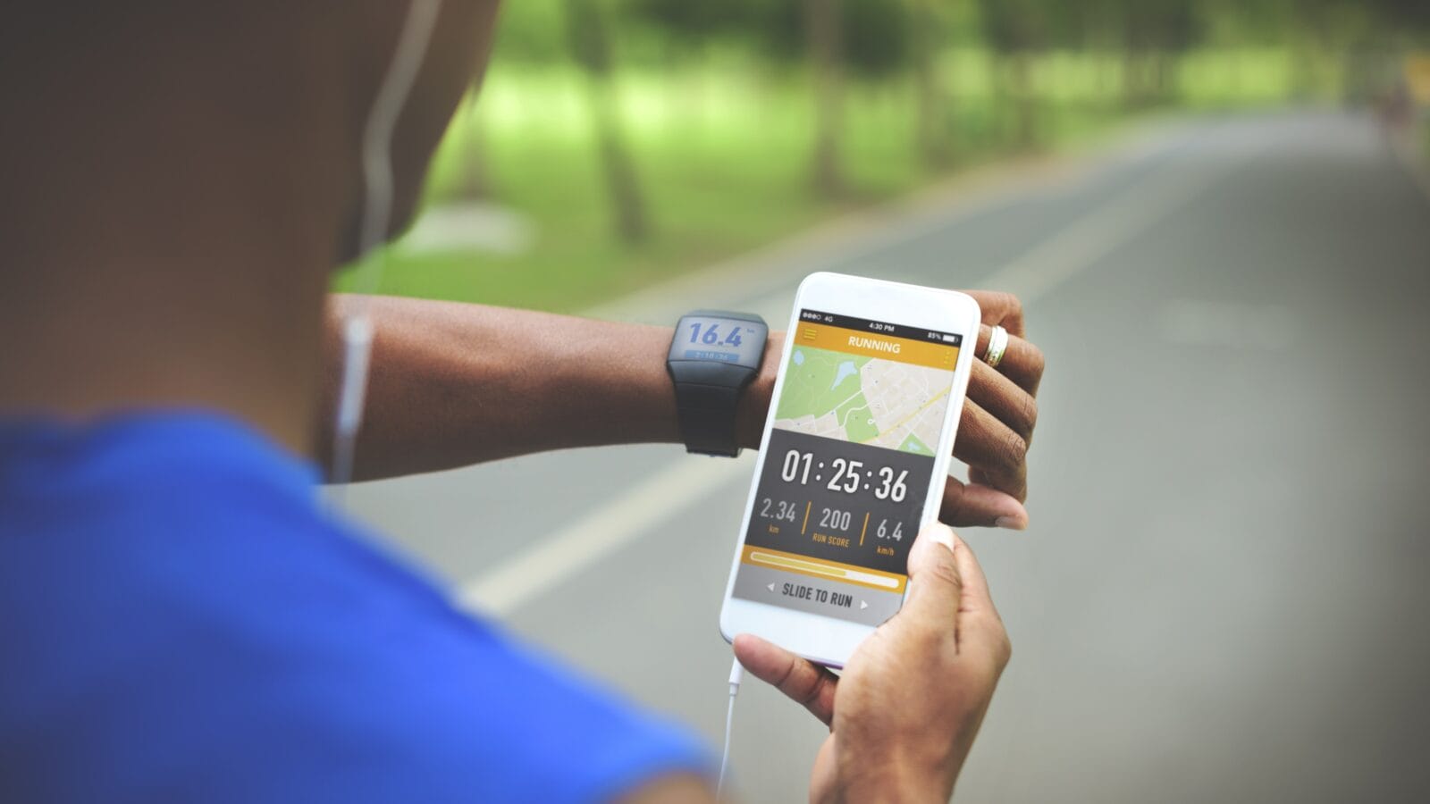 A person doing cardio and checking report on a phone.