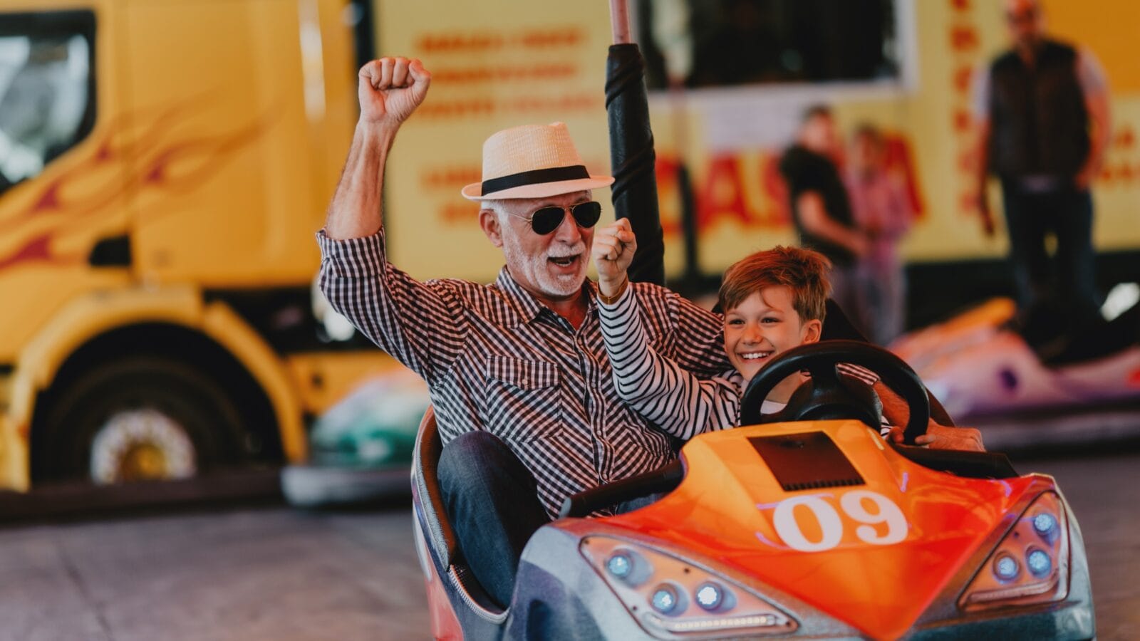 Grandfather and grandson having fun in amusement park.