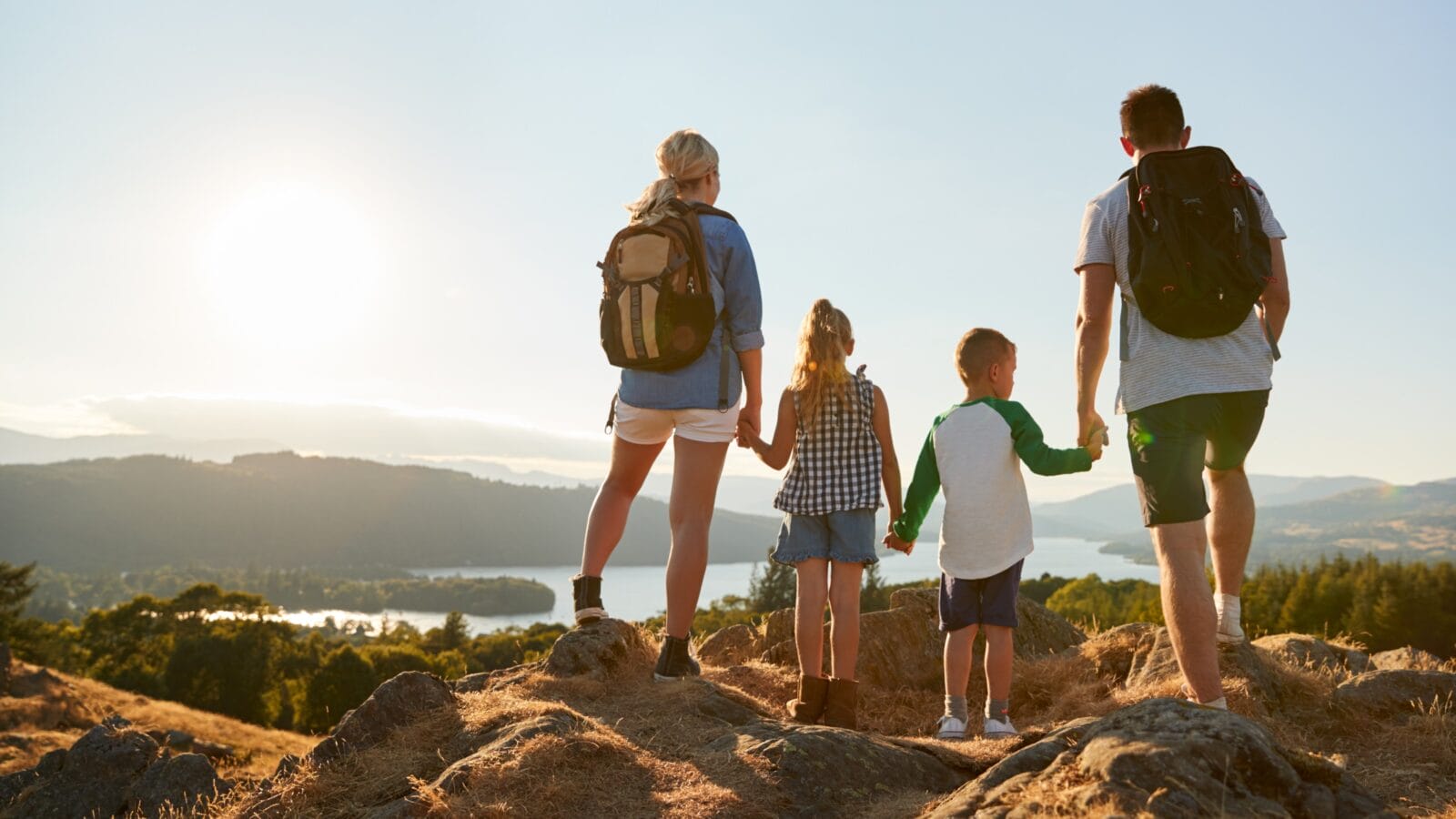 Family Standing At Top Of Hill On Hike Through Countryside