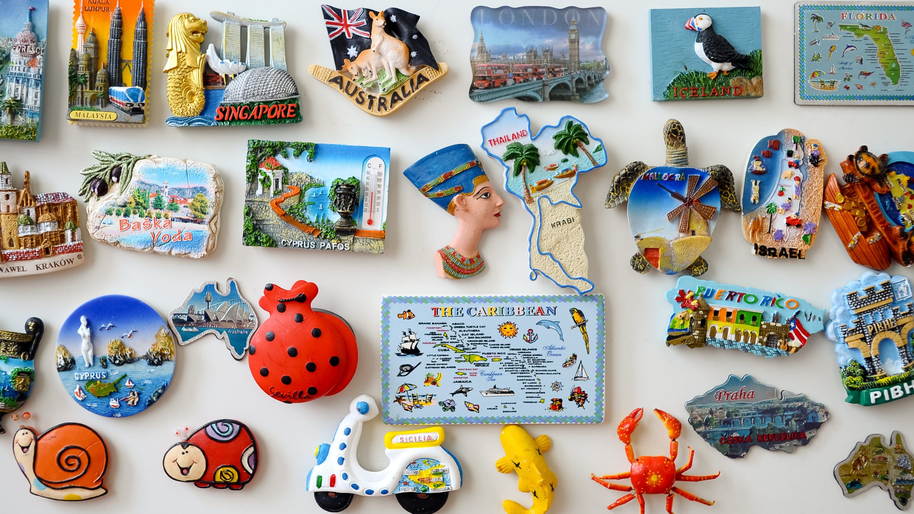 Travel magnets on a white fridge.