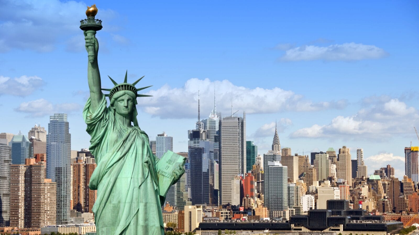 New York City skyline cityscape with Statue of Liberty over Hudson river.