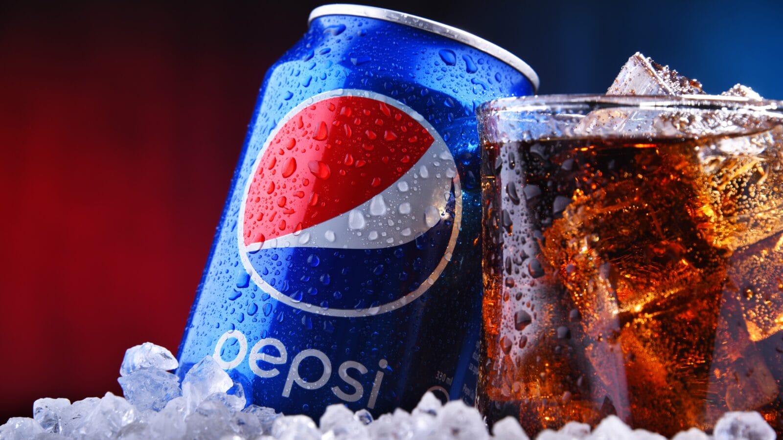 A can and a glass of Pepsi in a stack of ice.