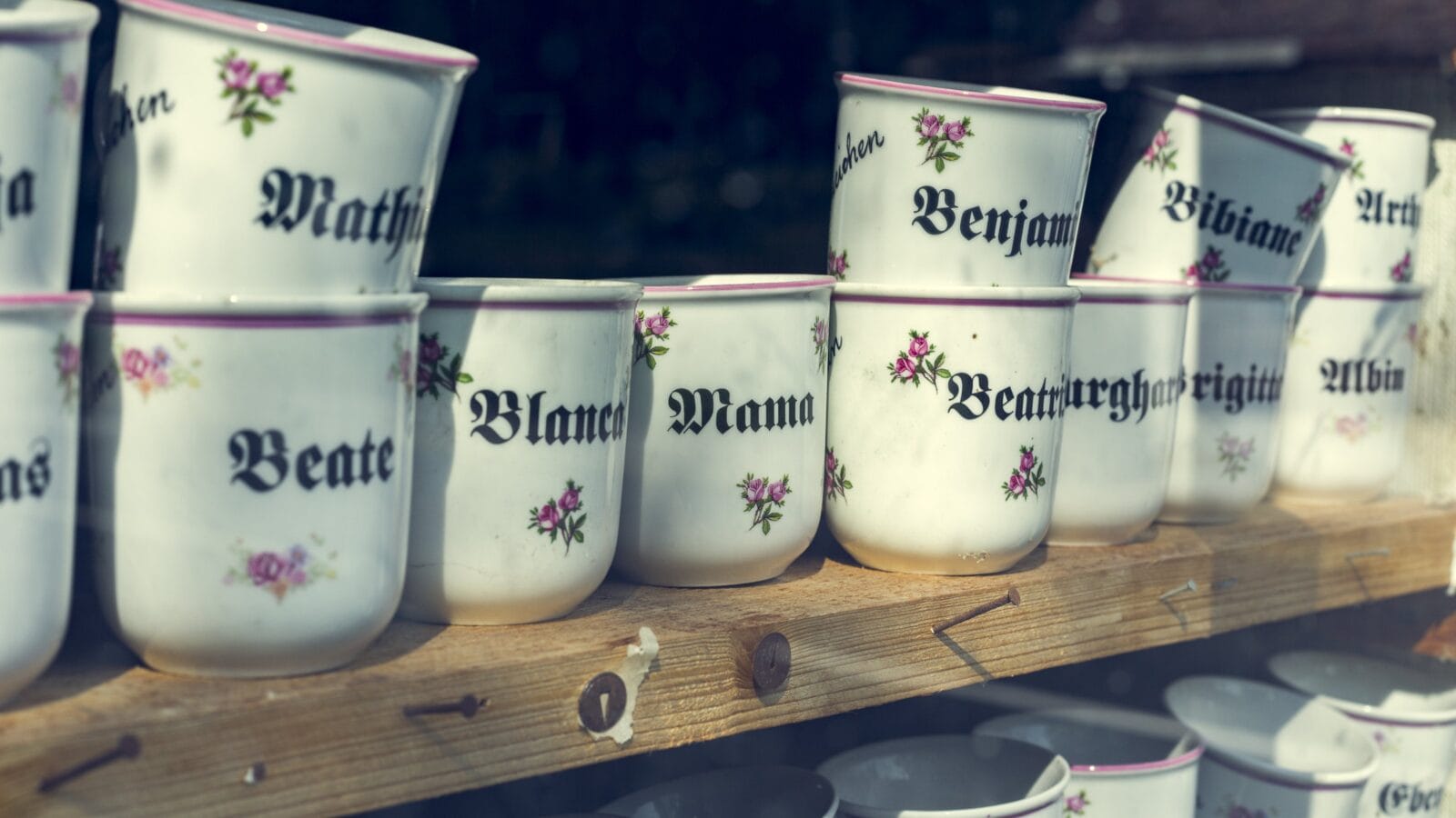 Coffee mugs on a wooden shelf.