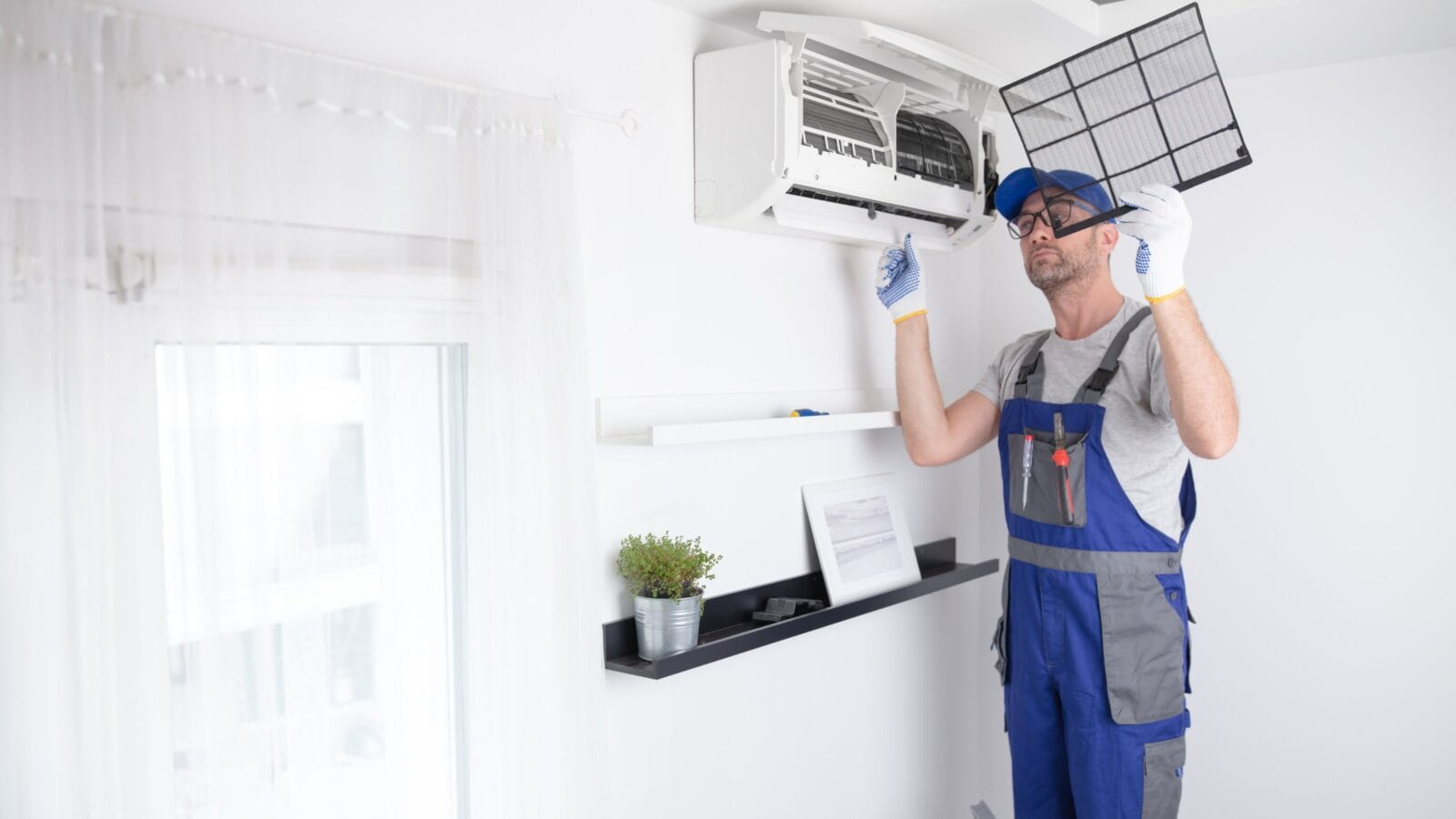 Service guy cleaning and maintaining air condition unit.