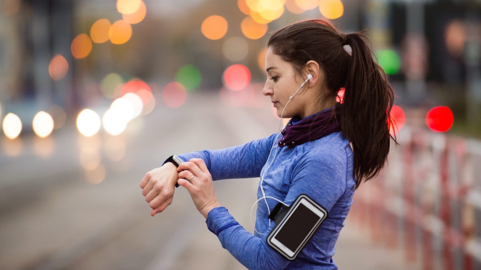 Young woman in blue sweatshirt running in the city.