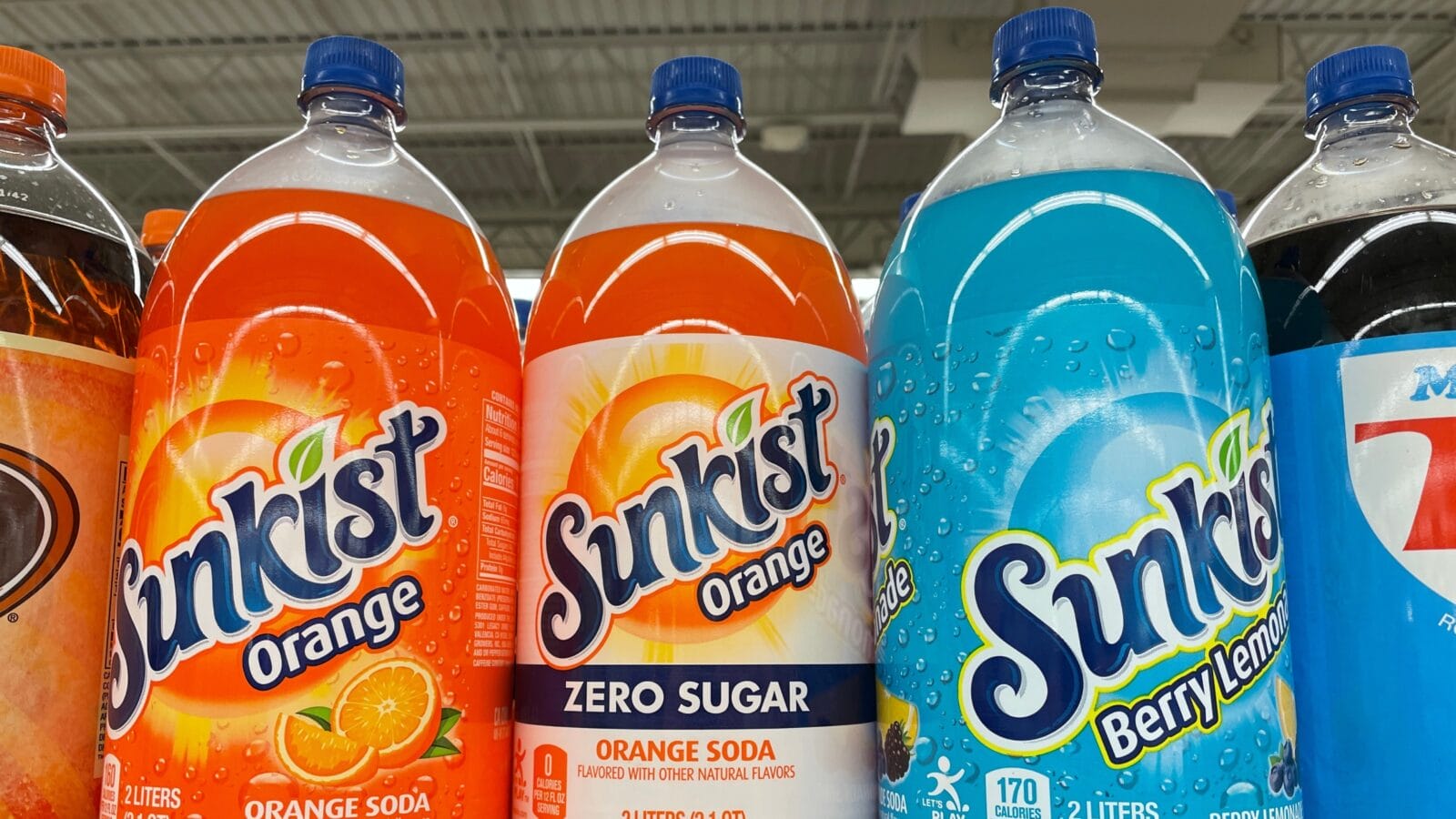 Different flavors of Sunkist on a shelf in grocery store.