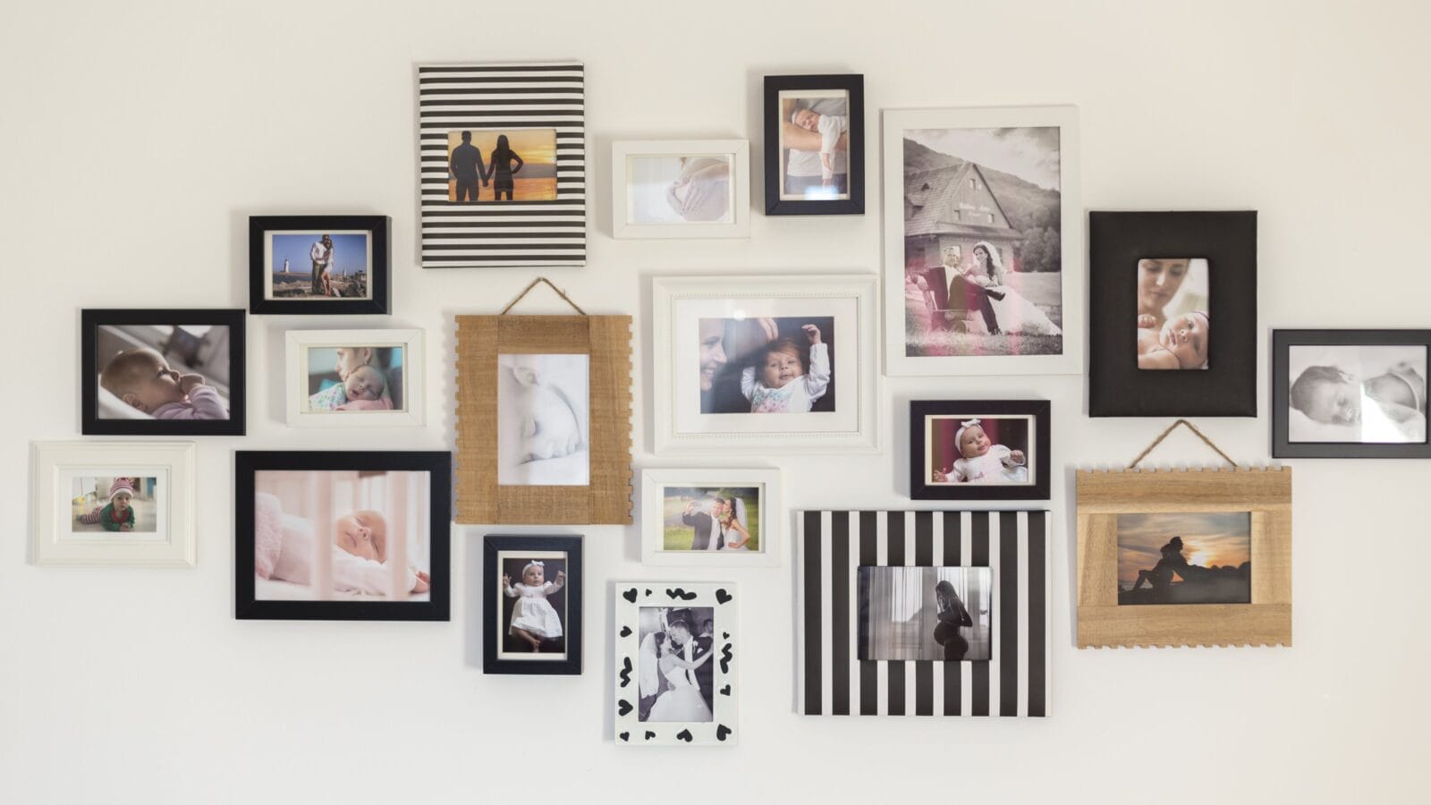 white wall with photos of the family in various photo frames