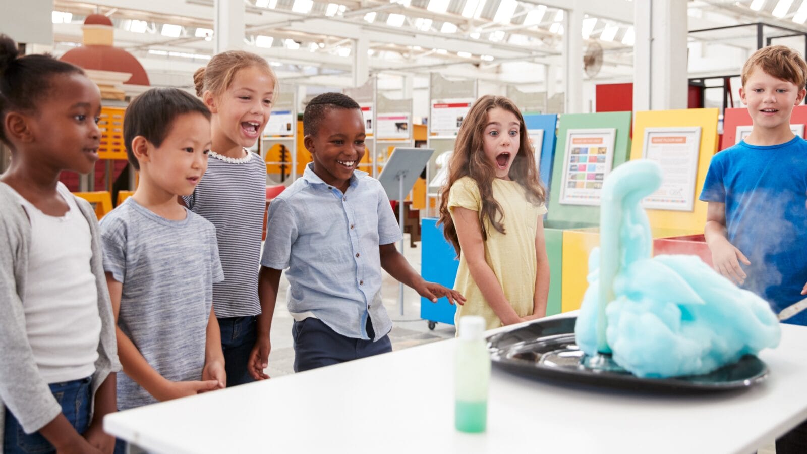 Kids having fun watching an experiment at a science centre