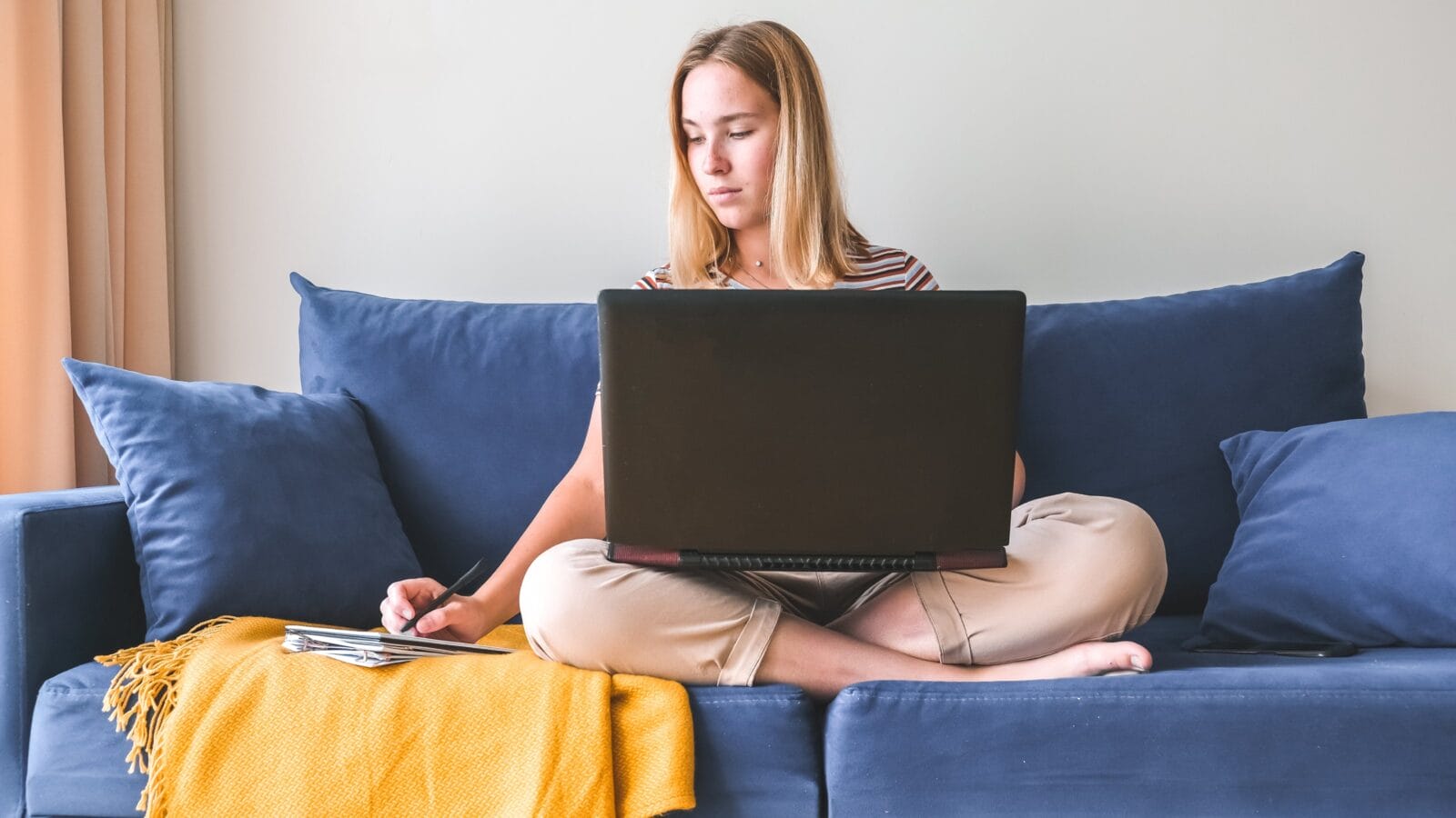 Girl sitting on a sofa and working from home.
