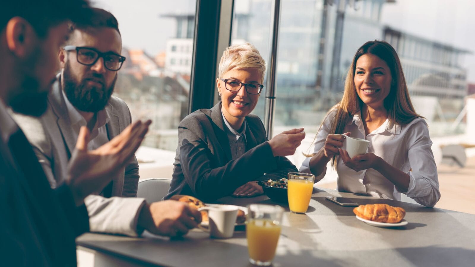 Group of business people having breakfast in company's restaurant