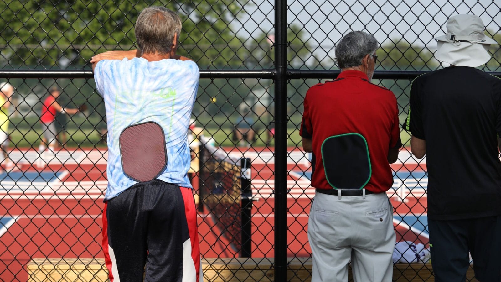 Two tournament players watch as they wait to play in their pickleball match