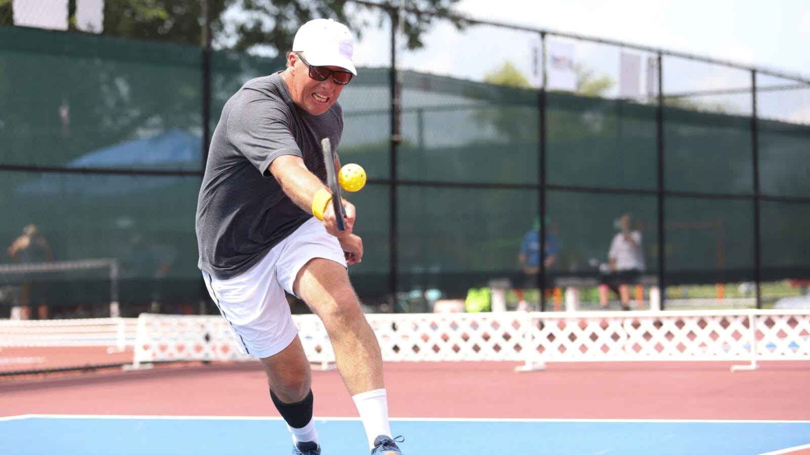 A tournament pickleball players hits a shot