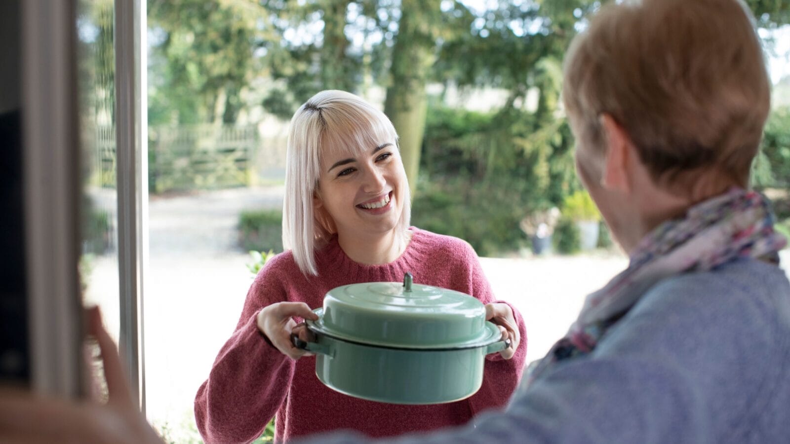 Woman Bringing Meal For Elderly Neighbour