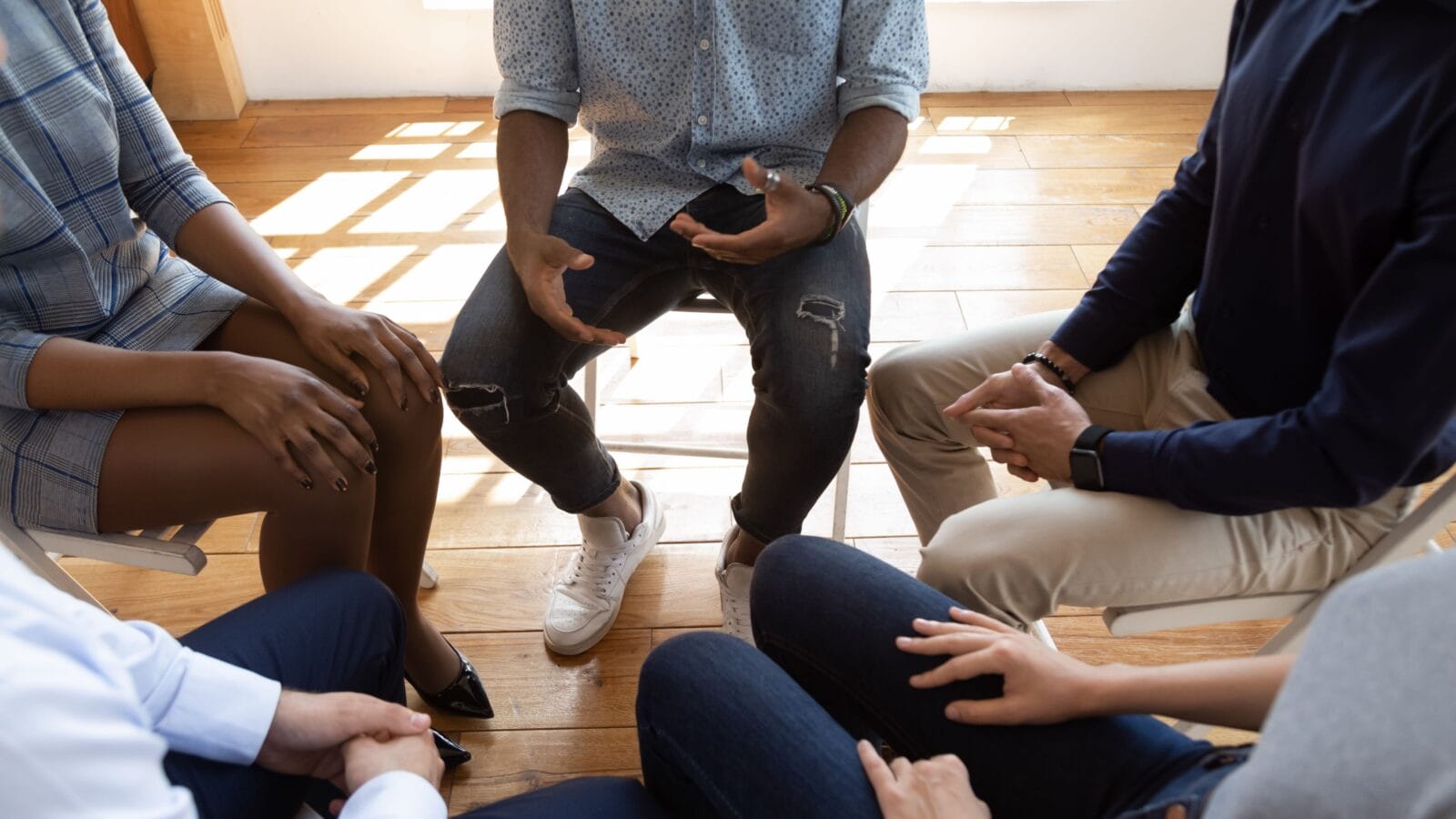 Close up top view unrecognizable multiracial workers strategizing indoors at informal atmosphere