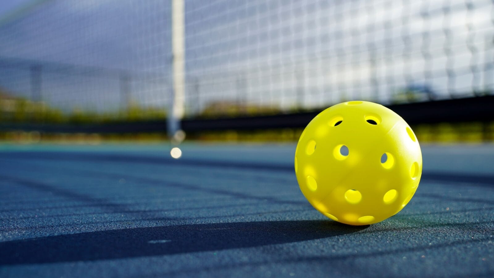 Close up of a pickleball on a pickleball court