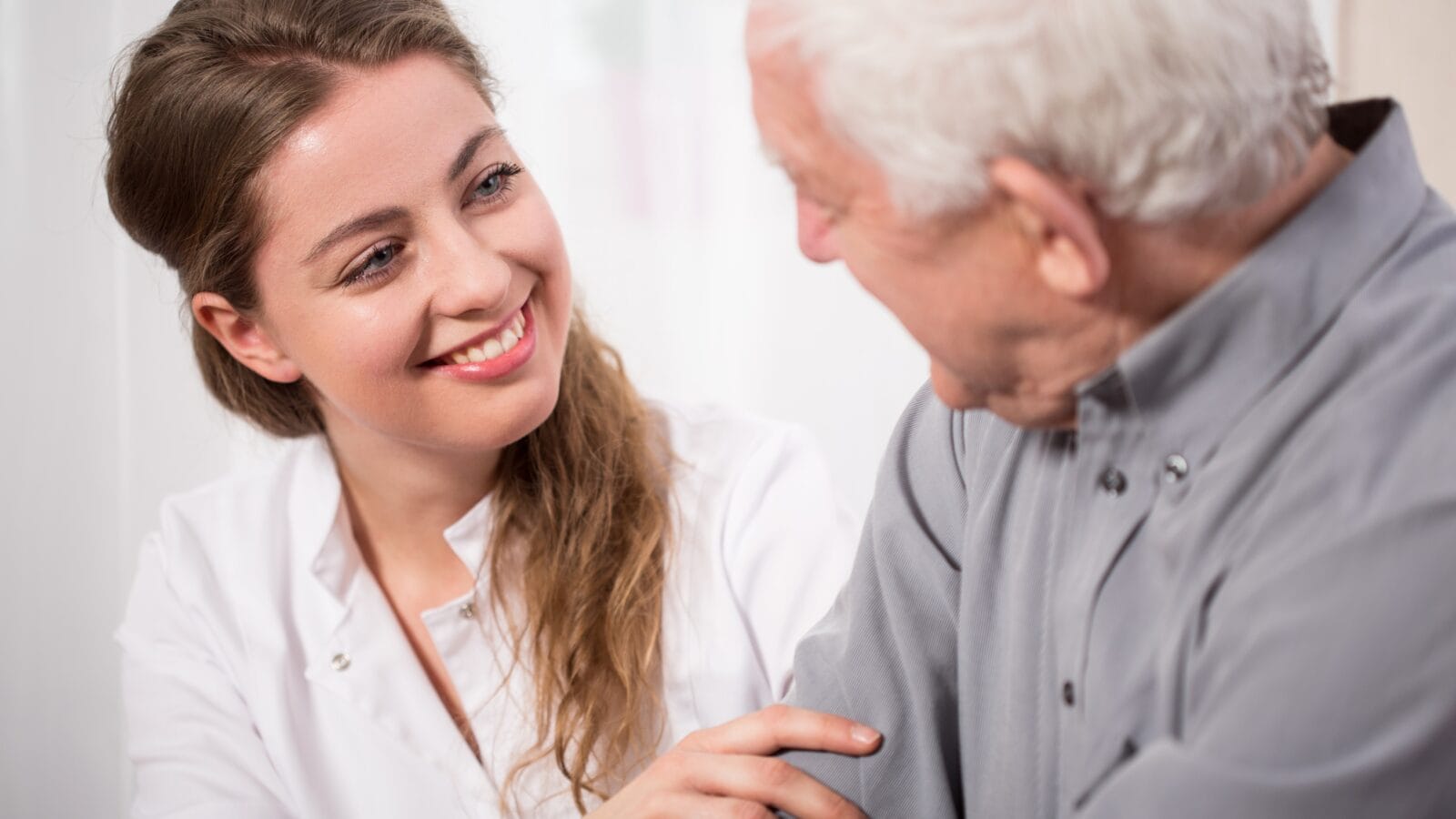 Picture of smiling nurse assisting senior man