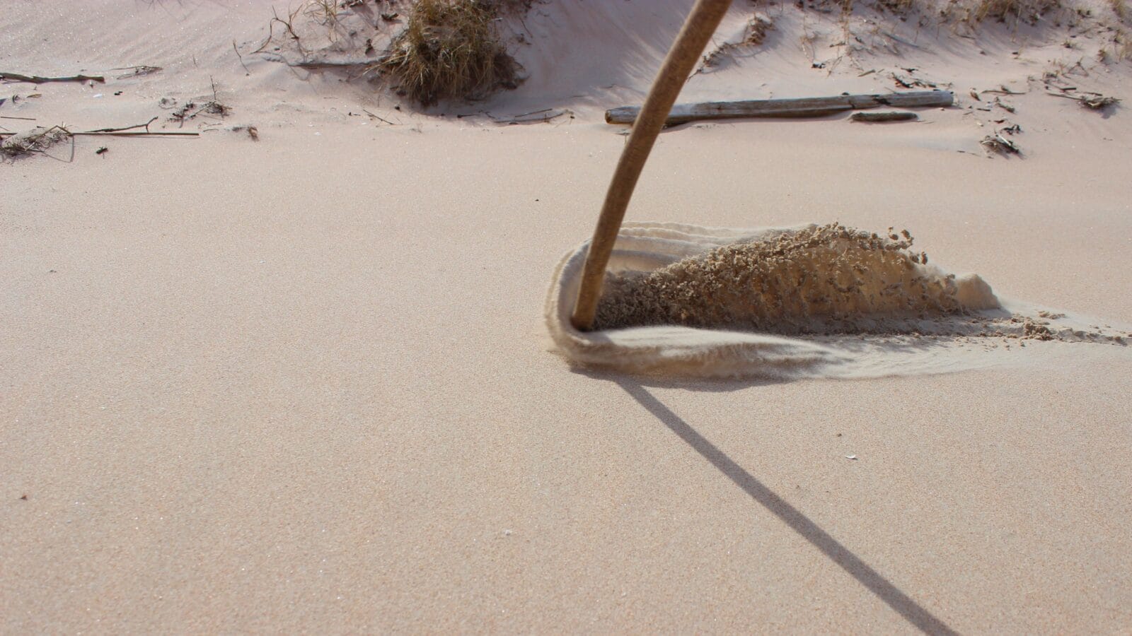 Sand waves as a result of dragging a stick along the ground