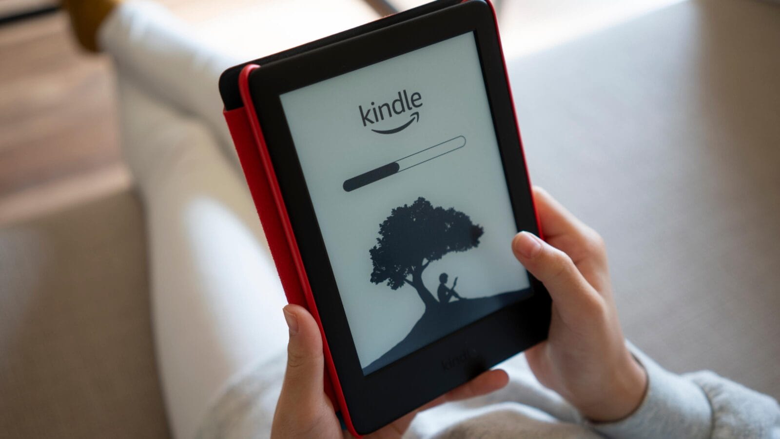 A girl opens her kindle to read ebooks at home.