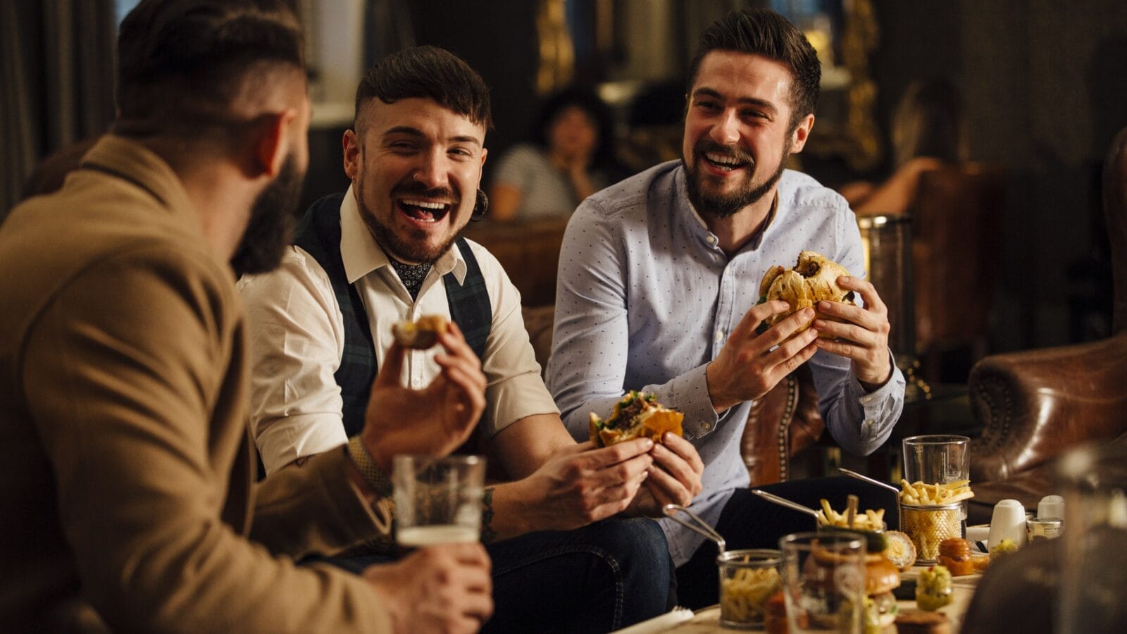 Three men are sitting together in a bar/restaurant lounge.