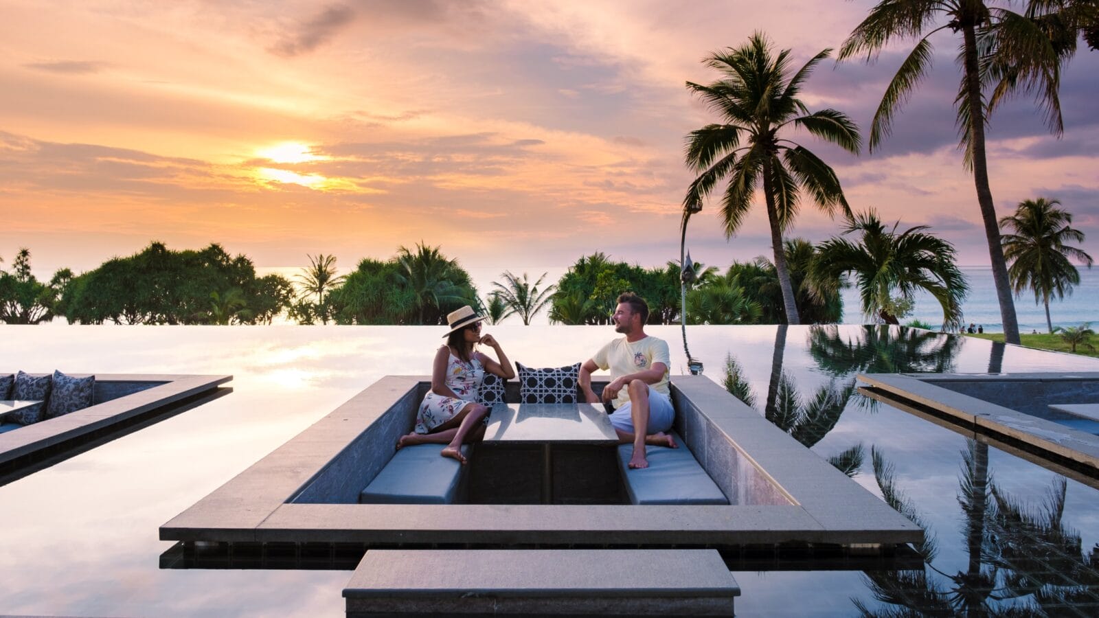 Couple watching the sunset in an infinity pool on a luxury vacation in Thailand