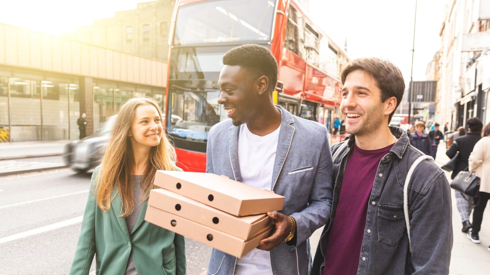 Happy friends with takeaway pizza in London
