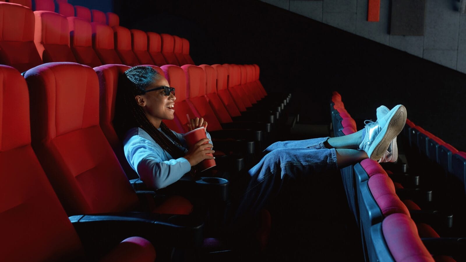 Young woman with 3d glasses watching a movie alone in cinema.