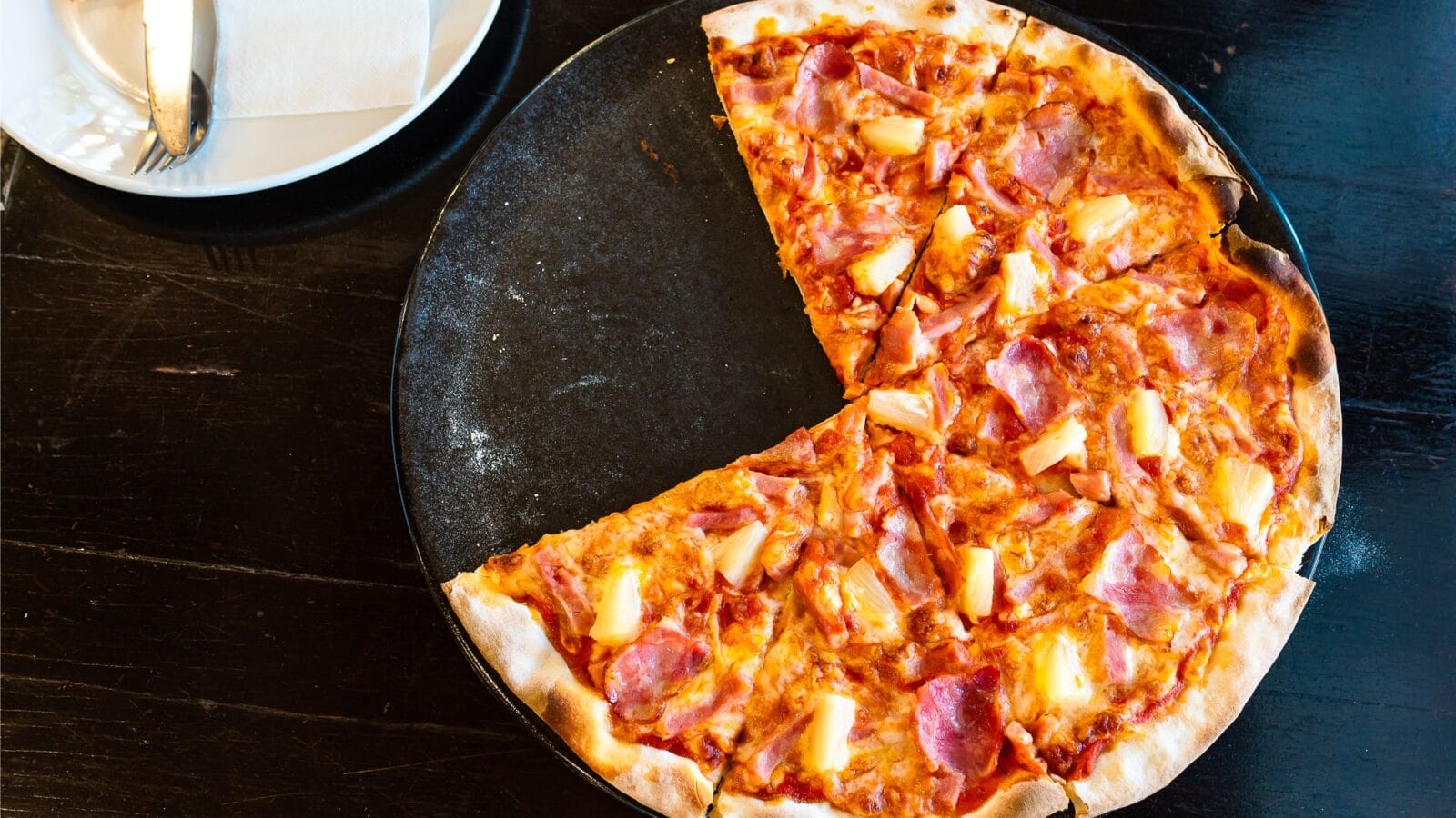 Sliced Hawaiian pizza with pineapple and ham