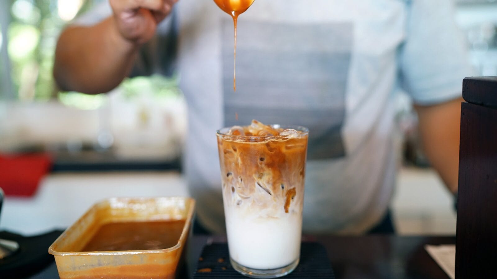 A glass of espresso mixed with vanilla syrup, milk and ice, topping with caramel syrup