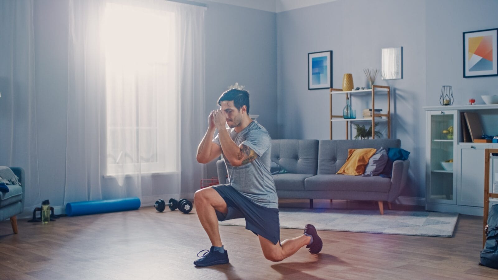 Strong Athletic Fit Man in T-shirt and Shorts is Doing Forward Lunge Exercises