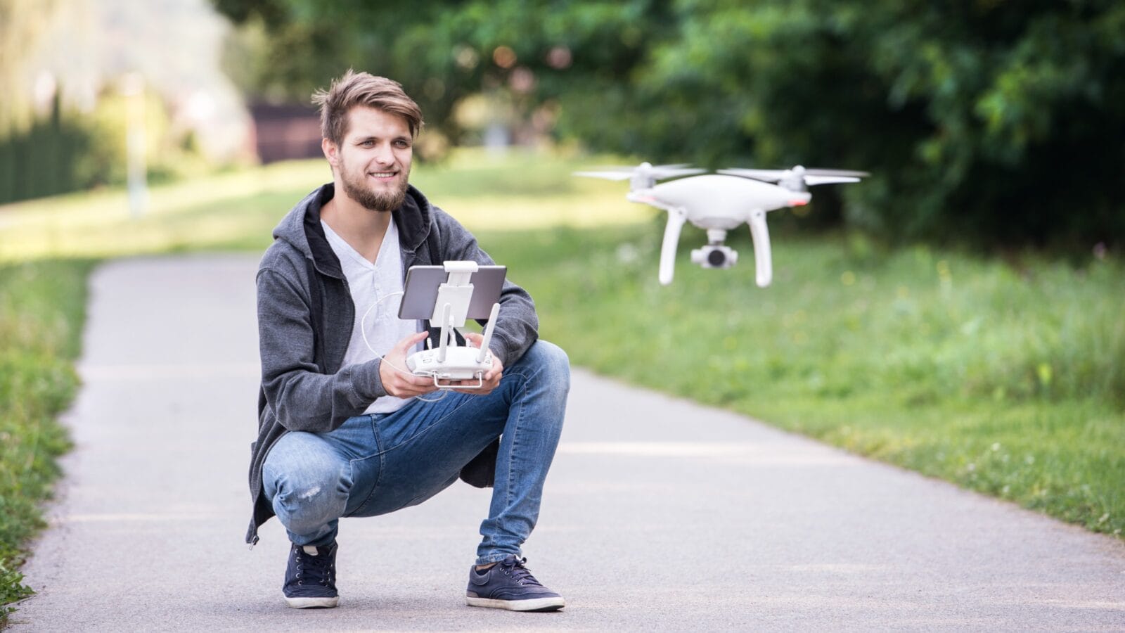 Young hipster man with flying drone.
