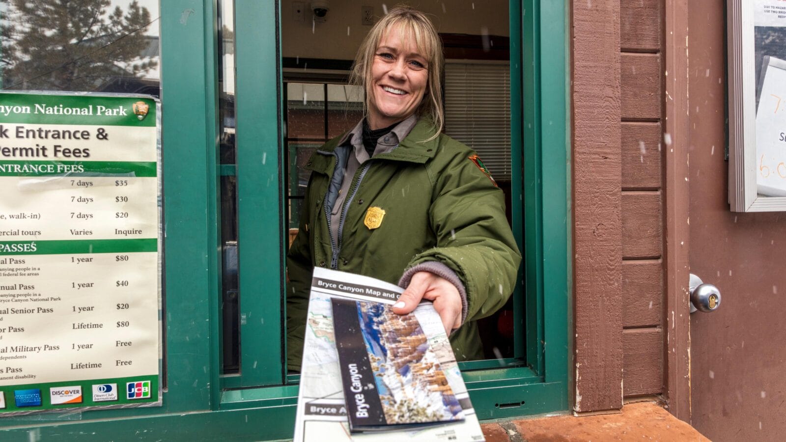 Female blond National Park Ranger hands out brochure through window at Bryce National Park, Utah