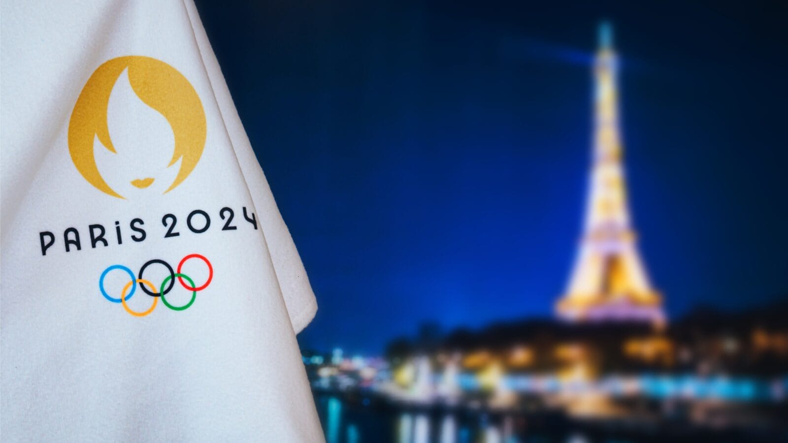 Official logo of SOG 2024 in Paris on white blanket with dark City in night.