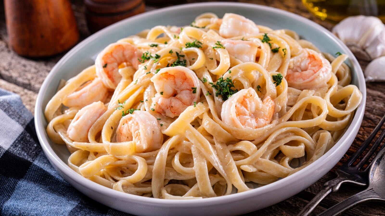 A plate of delicious shrimp alfredo with garlic and cream sauce over pasta.