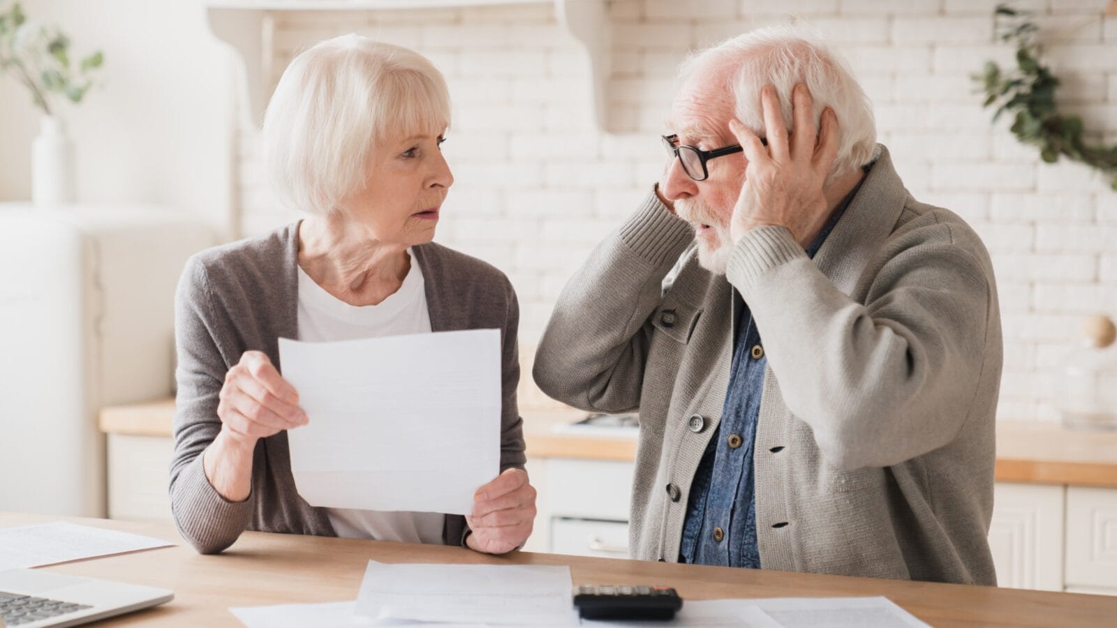 Senior elderly grandparents couple feeling shock sad in debts, bunkruptcy