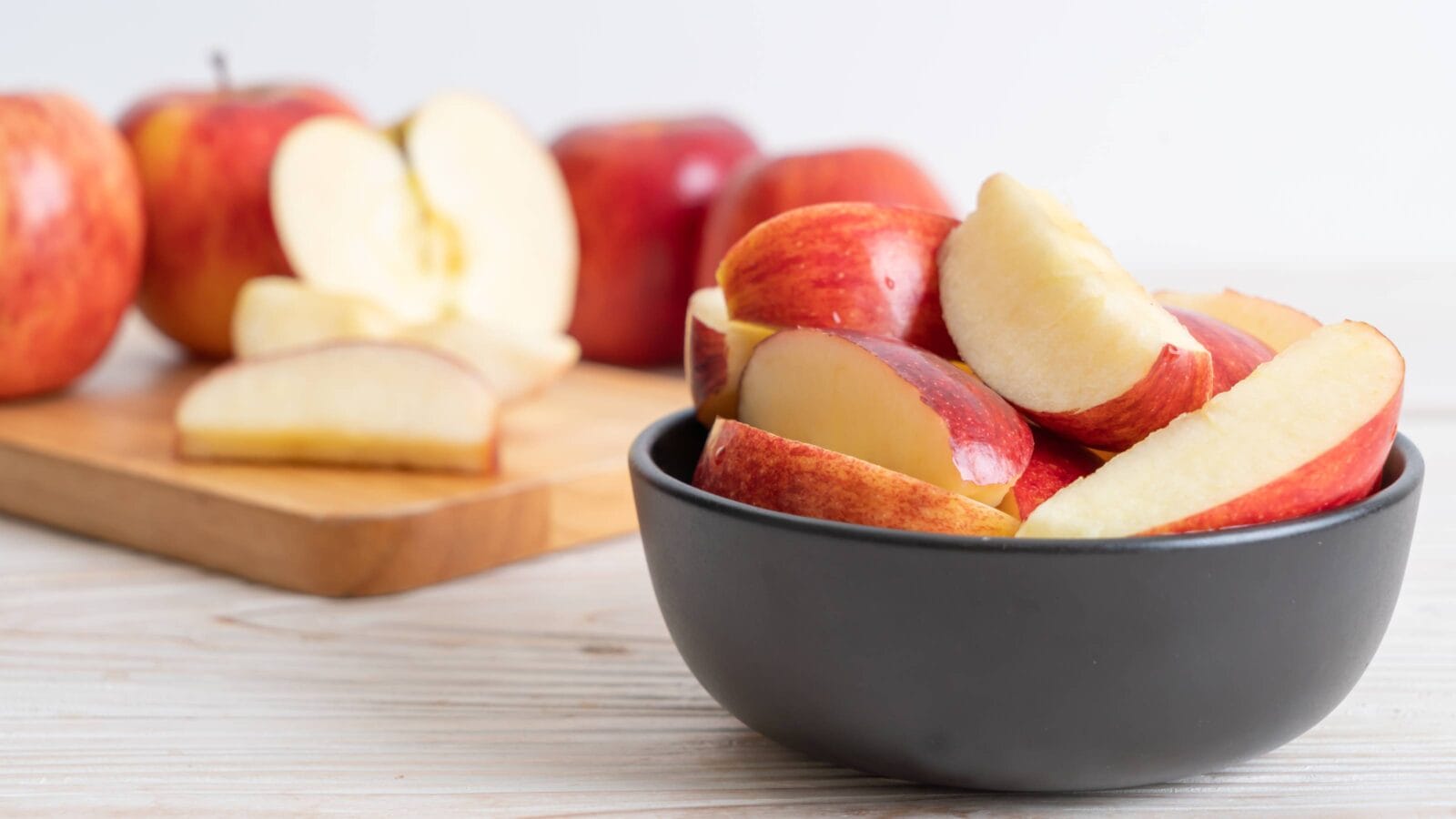 fresh red apples sliced bowl on wood background
