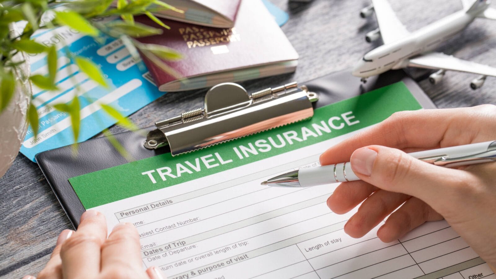 Travel insurance form, holding pen to fill it out.