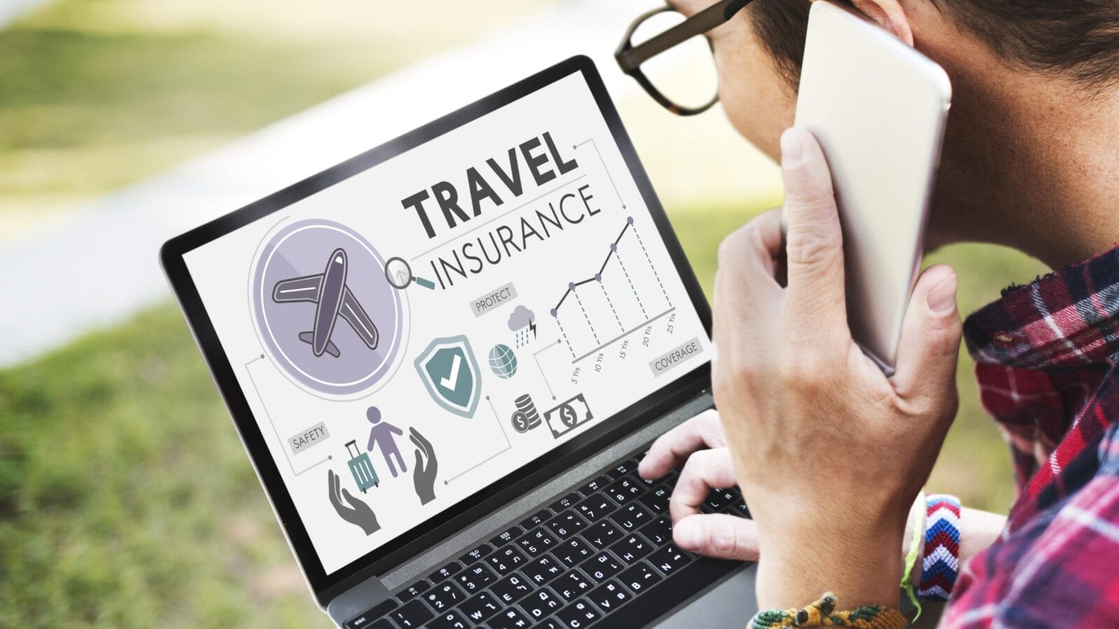 Man calling travel insurance while holding a laptop in his lap.