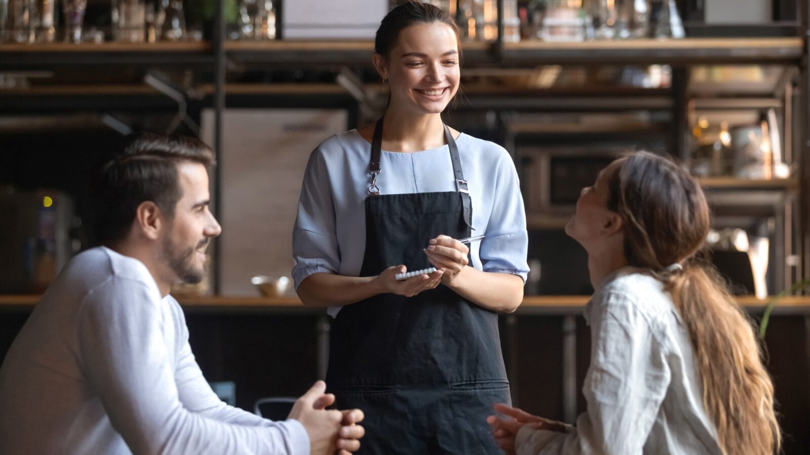 Smiling waitress wear apron hold notepad pen take order talk to clients