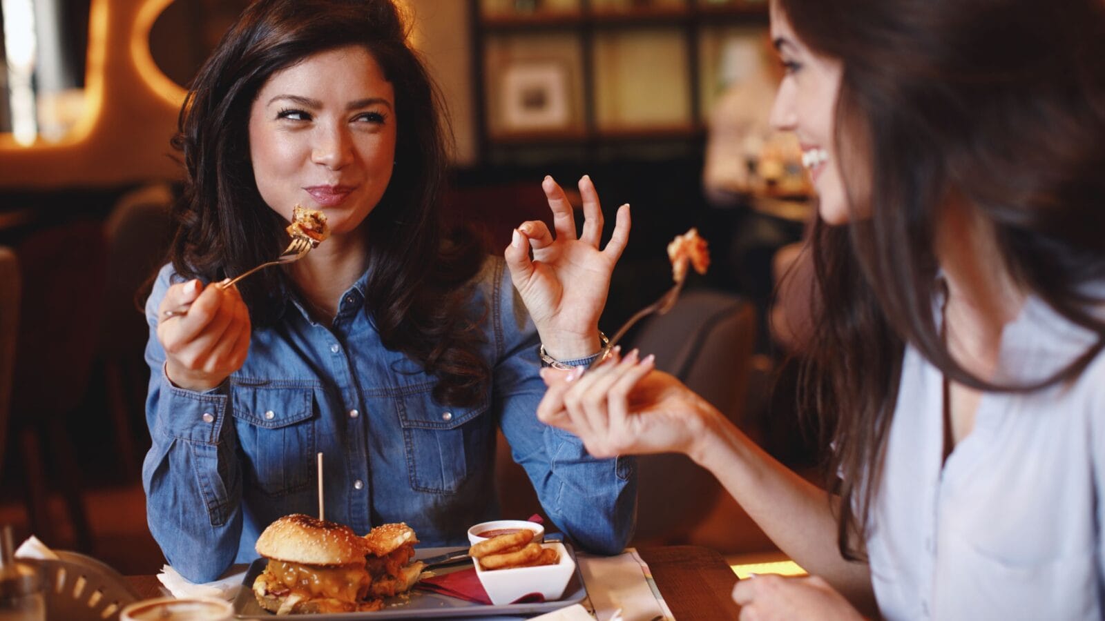 Two young women at a lunch in a restaurant